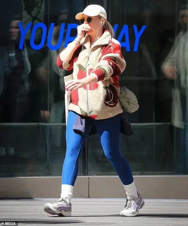 Scarlett Johansson dons an apple-print jacket, hat, and sunglasses as she carries two bags while trying to blend into the NYC crowd.