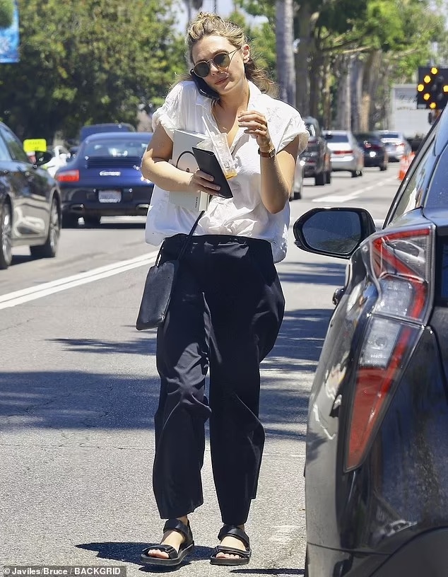 Elizabeth Olsen stuns with her relaxed yet fashionable look, pairing a white blouse with loose black trousers during a day out in LA.