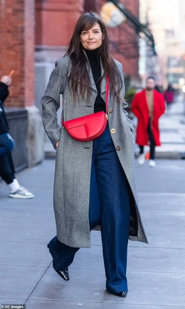 Katie Holmes Unveils Stylish Makeover: Chic in Black and White Coat with Striking Red Statement Bag on Dec 26, 2023